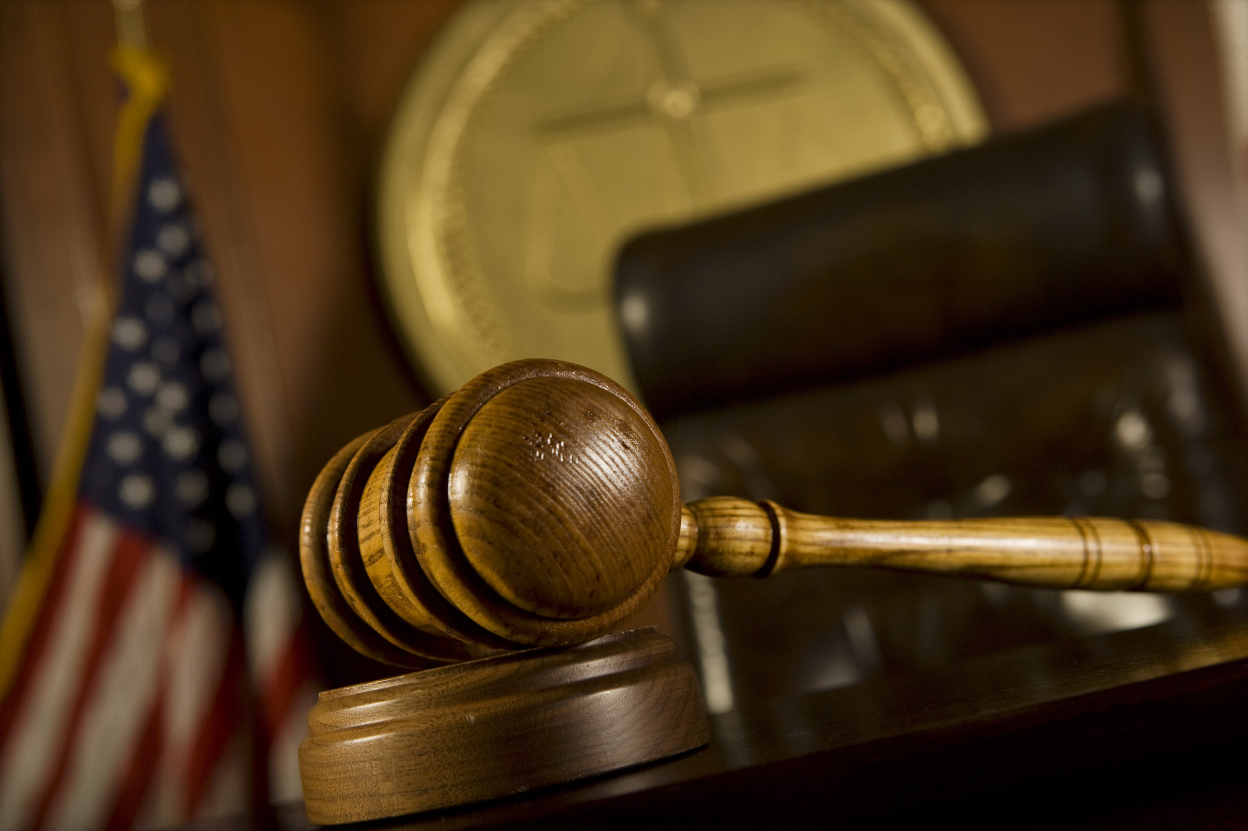 A gavel sitting on a judges desk in a court room