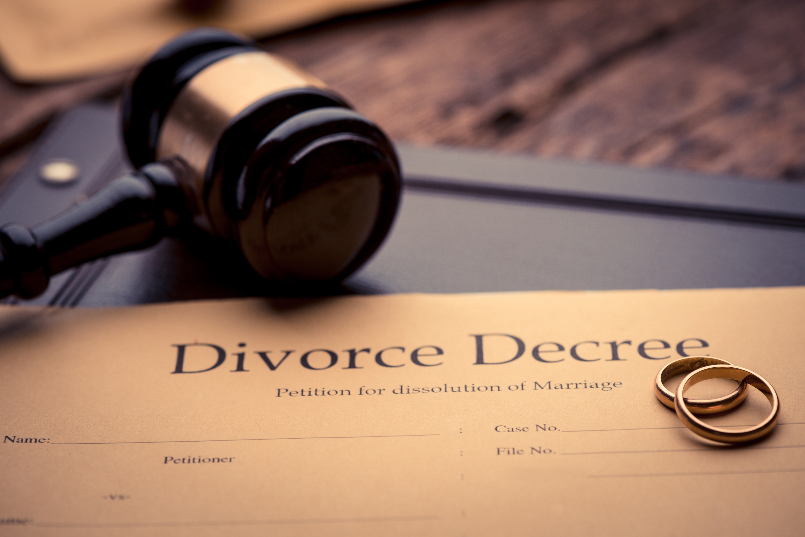 Divorce decree on a table with a gavel and wedding rings