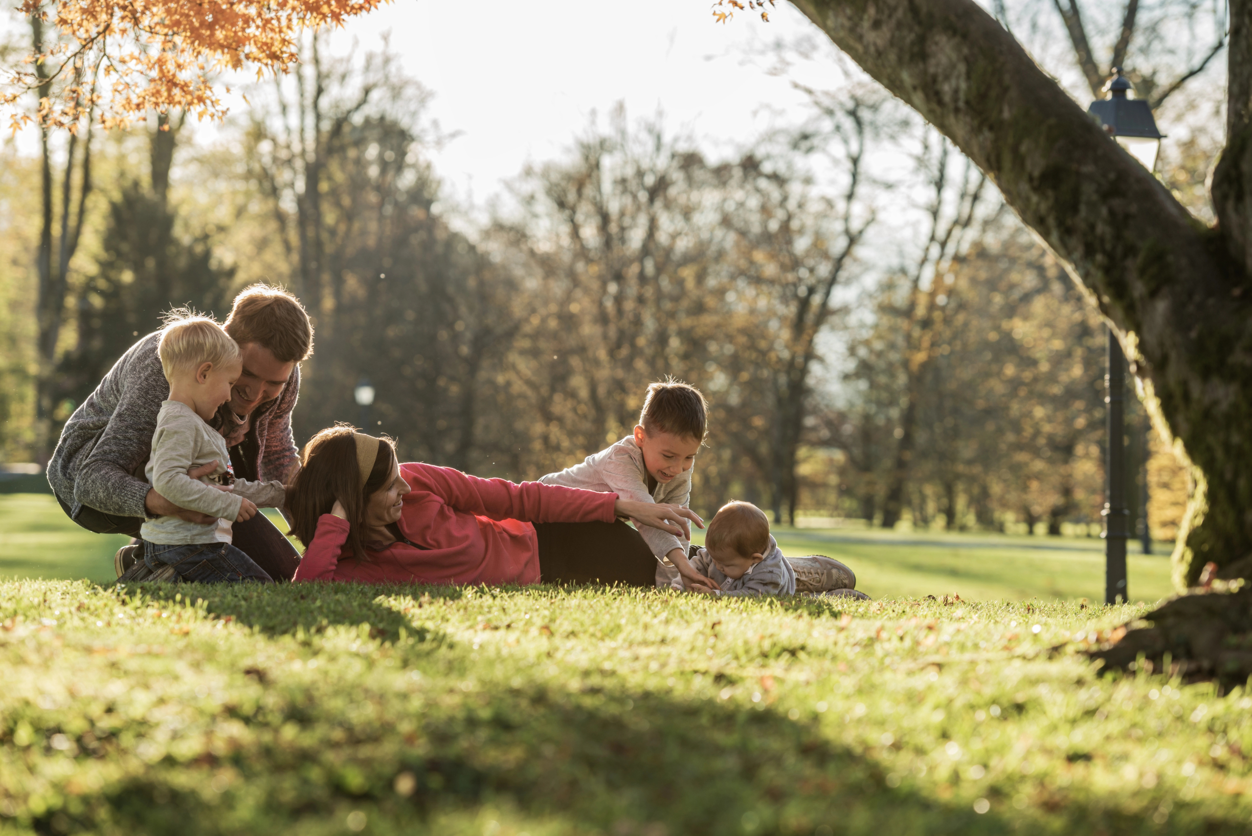 Family with young children playing in the grass