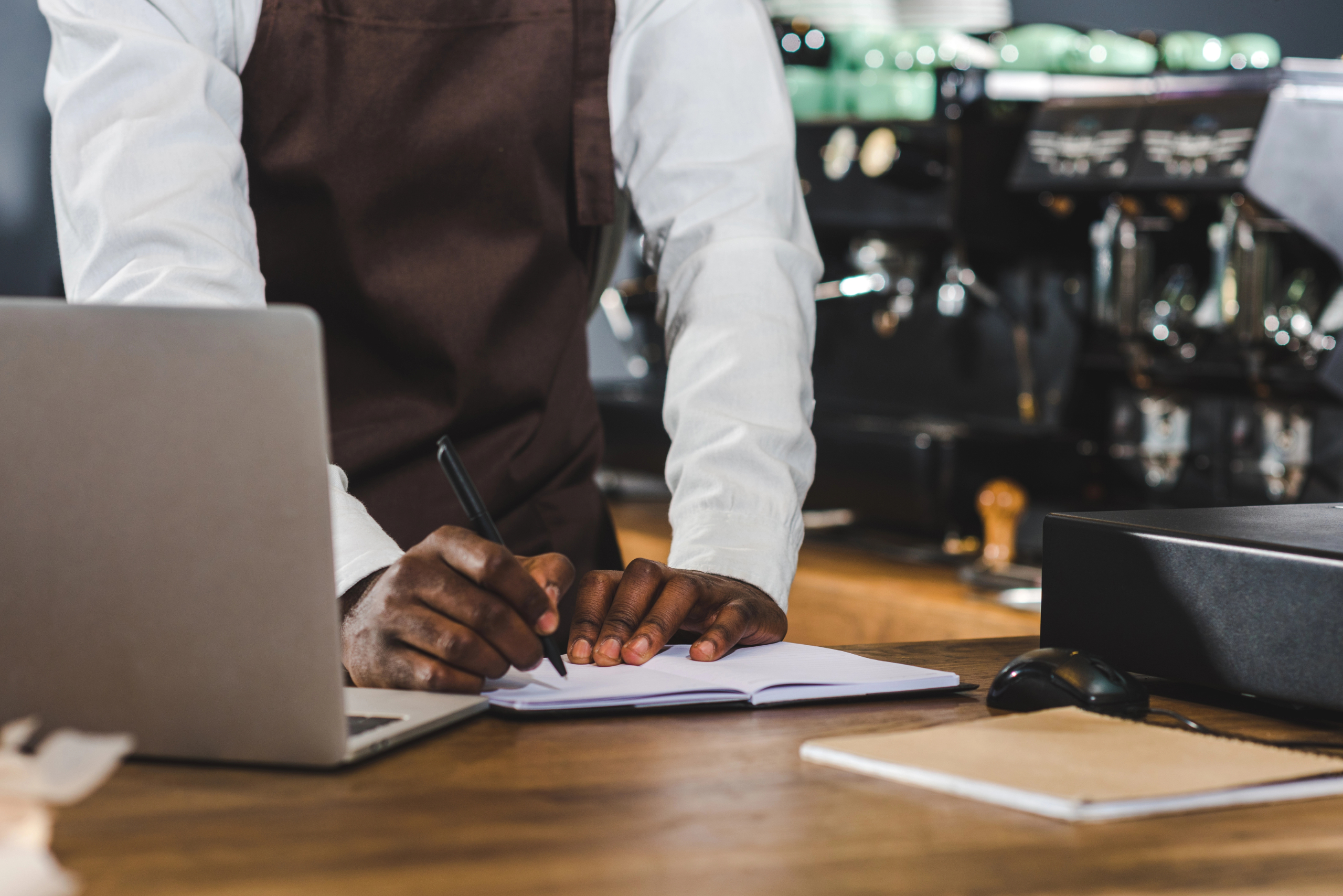 Man leaning over a counter taking notes